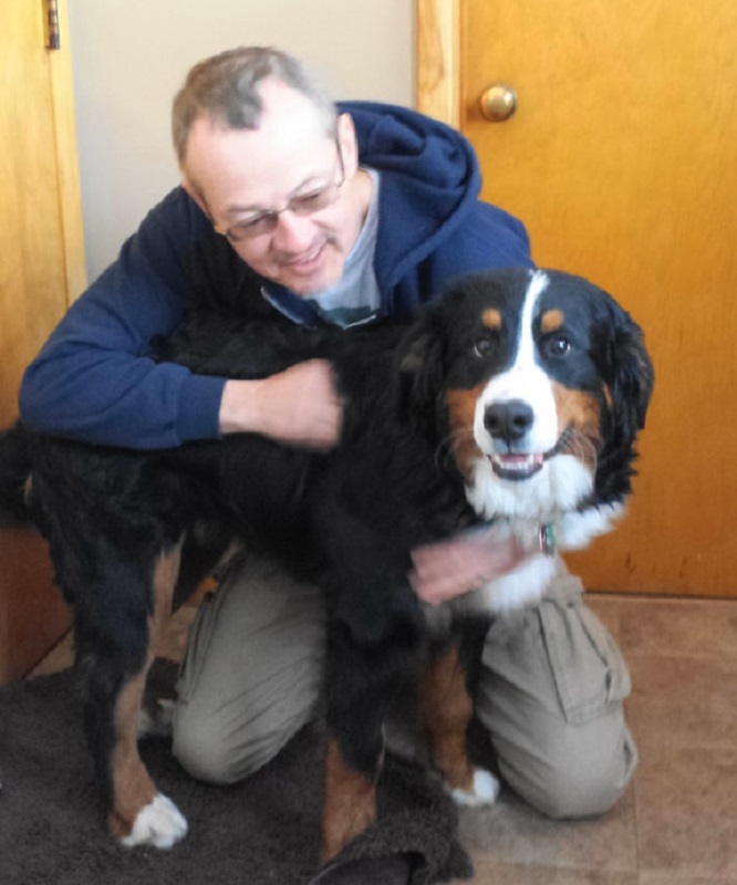 The author, Daniel H. Antolec, sitting on the floor with a large dog.